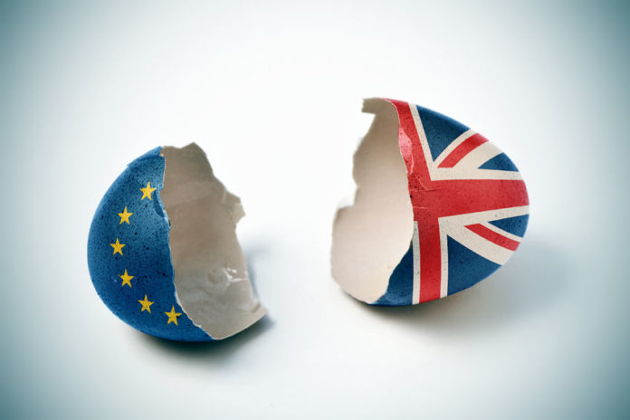 the two halves of a cracked eggshell, one patterned with the flag of the european community and the other one patterned with the flag of the united kingdom