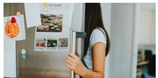 A girl looking at the fridge.