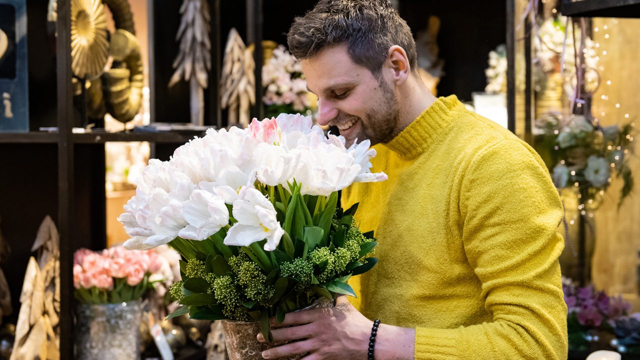 Floradecora trade fair. An image of a man smelling a bucket of flowers.